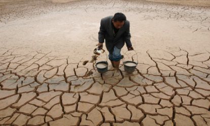 A farmer takes water from a dried-up pond to water his vegetable field during a drought in Jiangxi province. Photograph: Stringer Shanghai/Reuters (Courtesy of guardian.co.uk) 